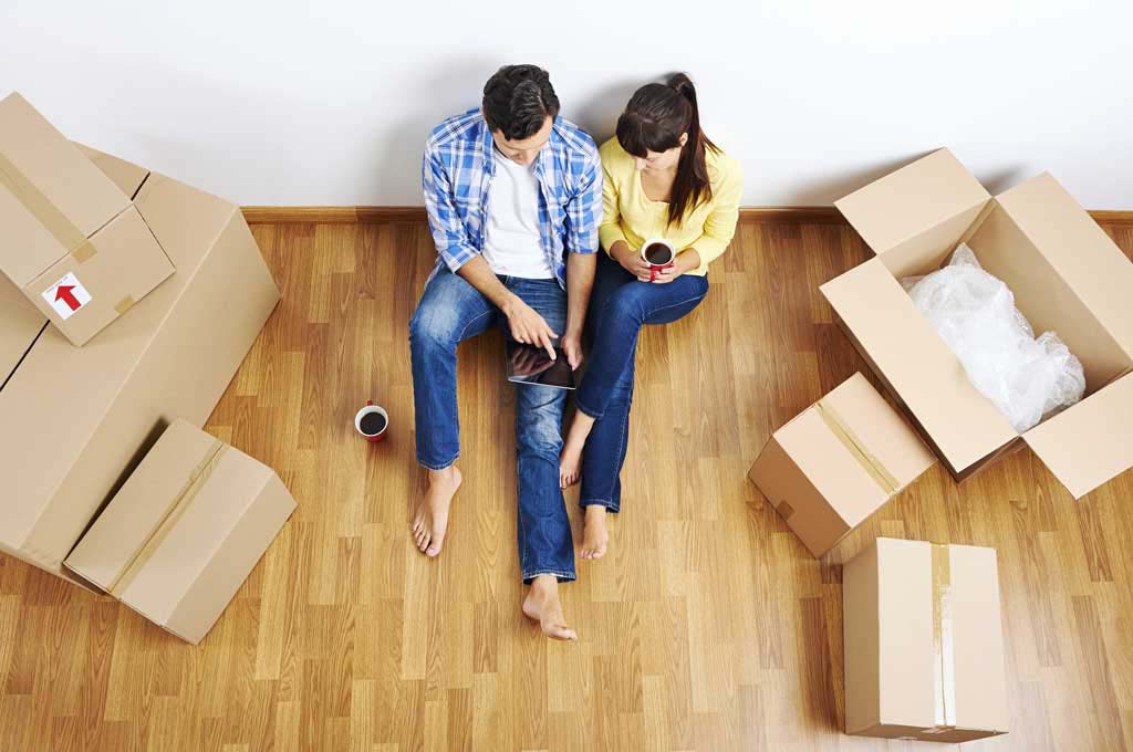 Couple sitting amongst their moving boxes