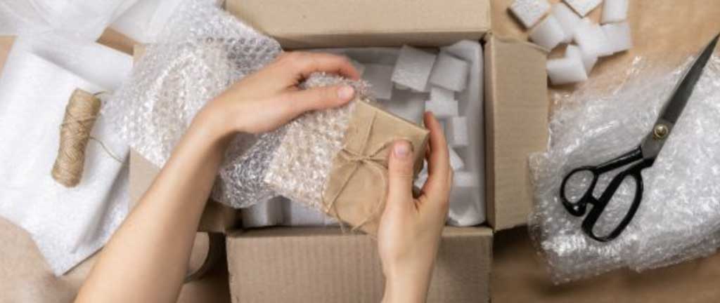 Person wrapping items then putting into box