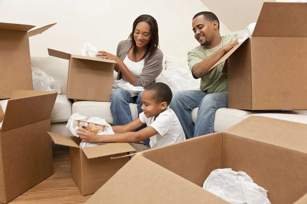 Happy black family packing their boxes