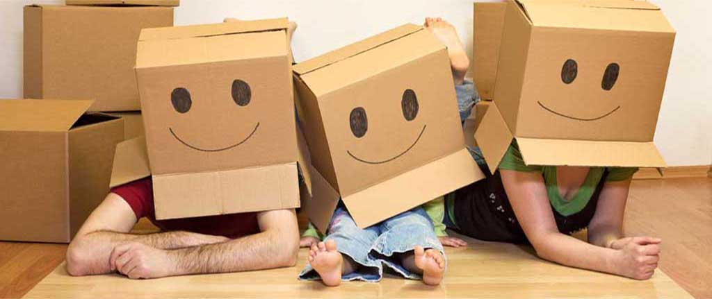 Family wearing boxes on their heads with happy faces drawn on the boxes